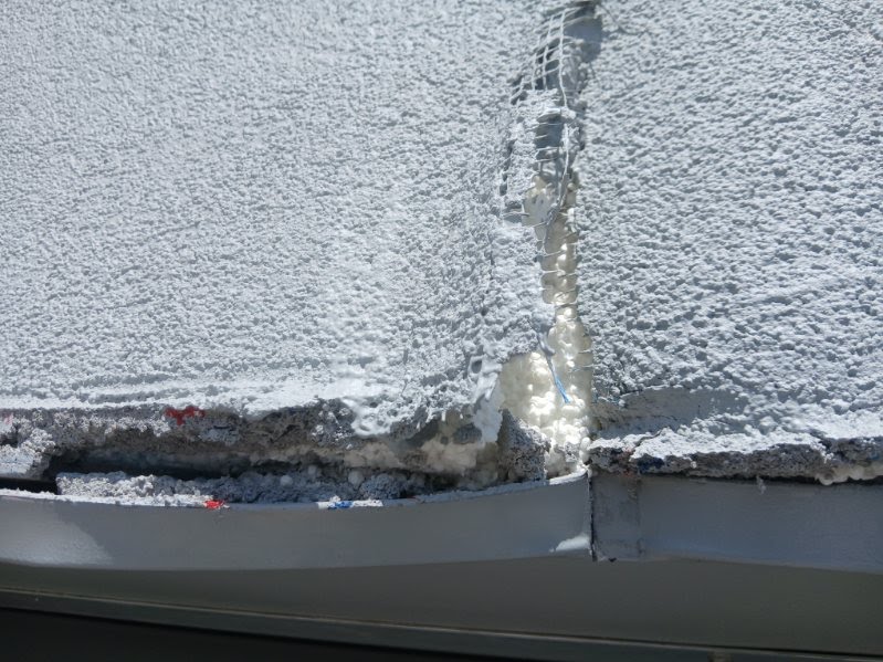 Cracked exterior finish with exposed mesh and sealant
