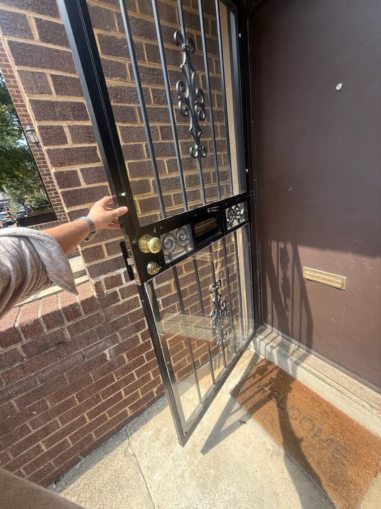 Installed metal security door at a brick entry