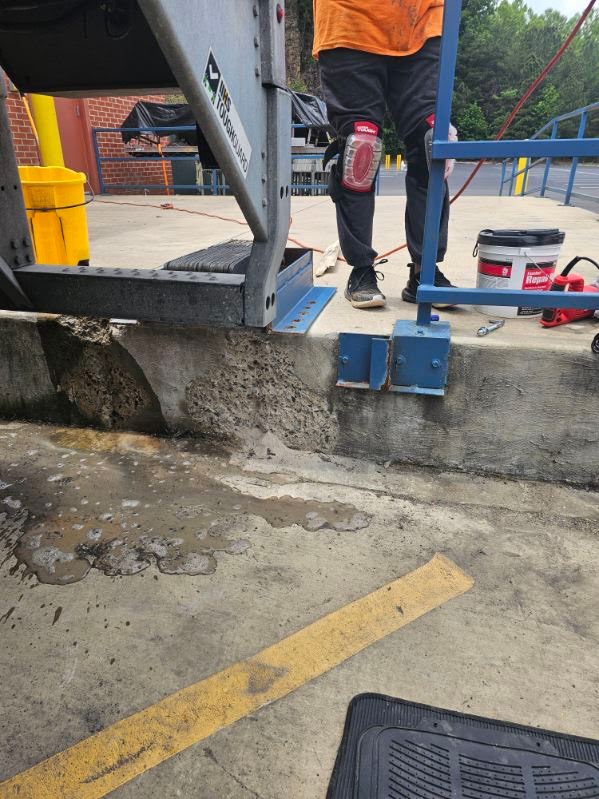 Technician completing a concrete repair at a commercial loading area