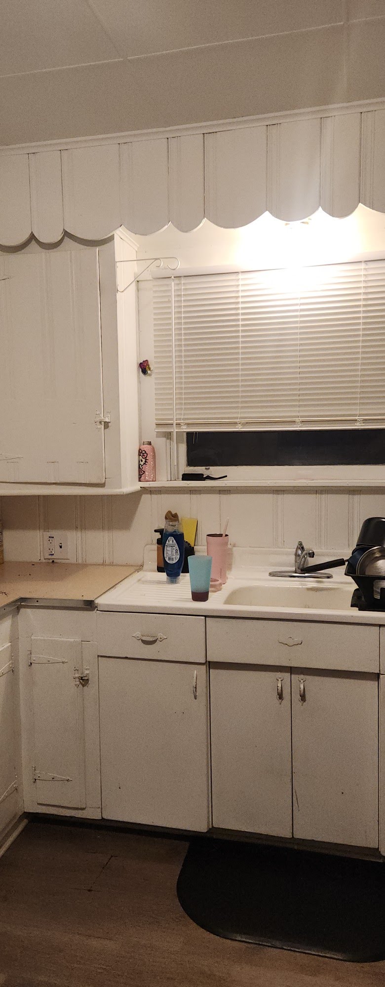 Kitchen sink, cabinetry, outlet, and surrounding finish