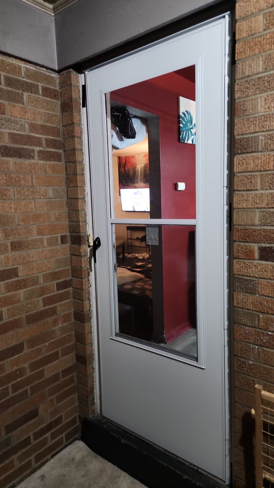 Installed exterior storm door in a brick opening