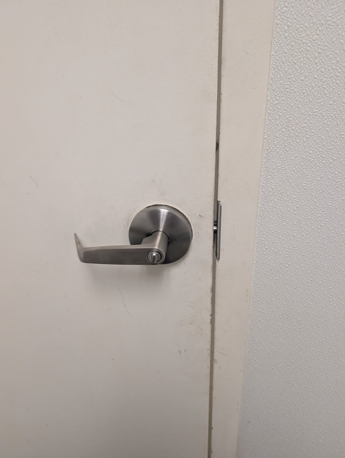 Commercial lever handle and latch installed on a door